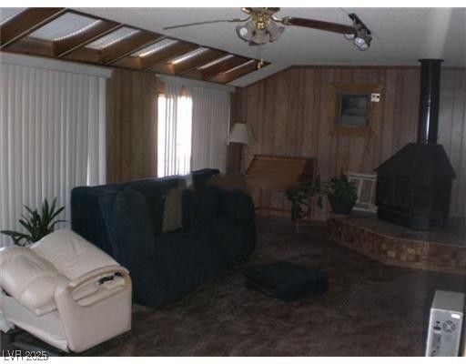332 Huntly Road Las Vegas, NV 89145 - Photo 6 of 7 Living room featuring a wood stove, wood walls, a