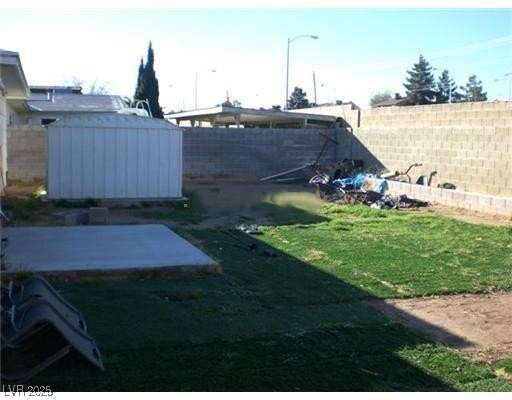 332 Huntly Road Las Vegas, NV 89145 - Photo 7 of 7 Fenced backyard with a storage unit