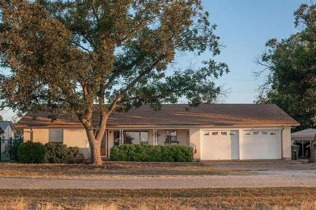 a front view of house with yard and trees