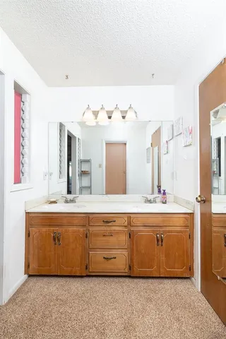 a spacious bathroom with a tub sink and mirror