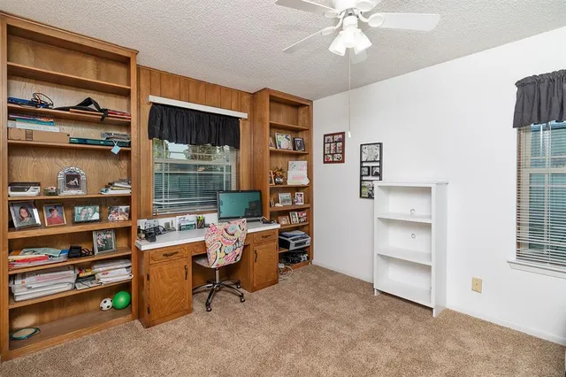 a view of a workspace with furniture and a window