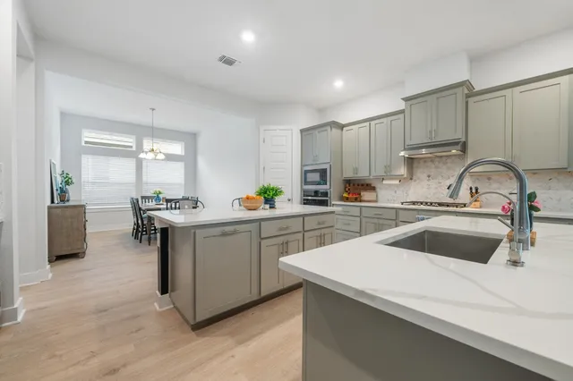 a kitchen with a sink white cabinets and white appliances