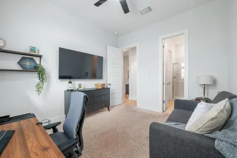 a bedroom with furniture and a flat screen tv