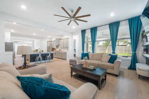 a living room with furniture and a large window with wooden floor