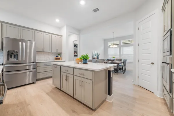 a kitchen with stainless steel appliances a sink a stove a refrigerator and cabinets
