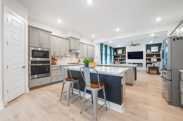 a kitchen with stainless steel appliances kitchen island granite countertop a refrigerator and a stove top oven