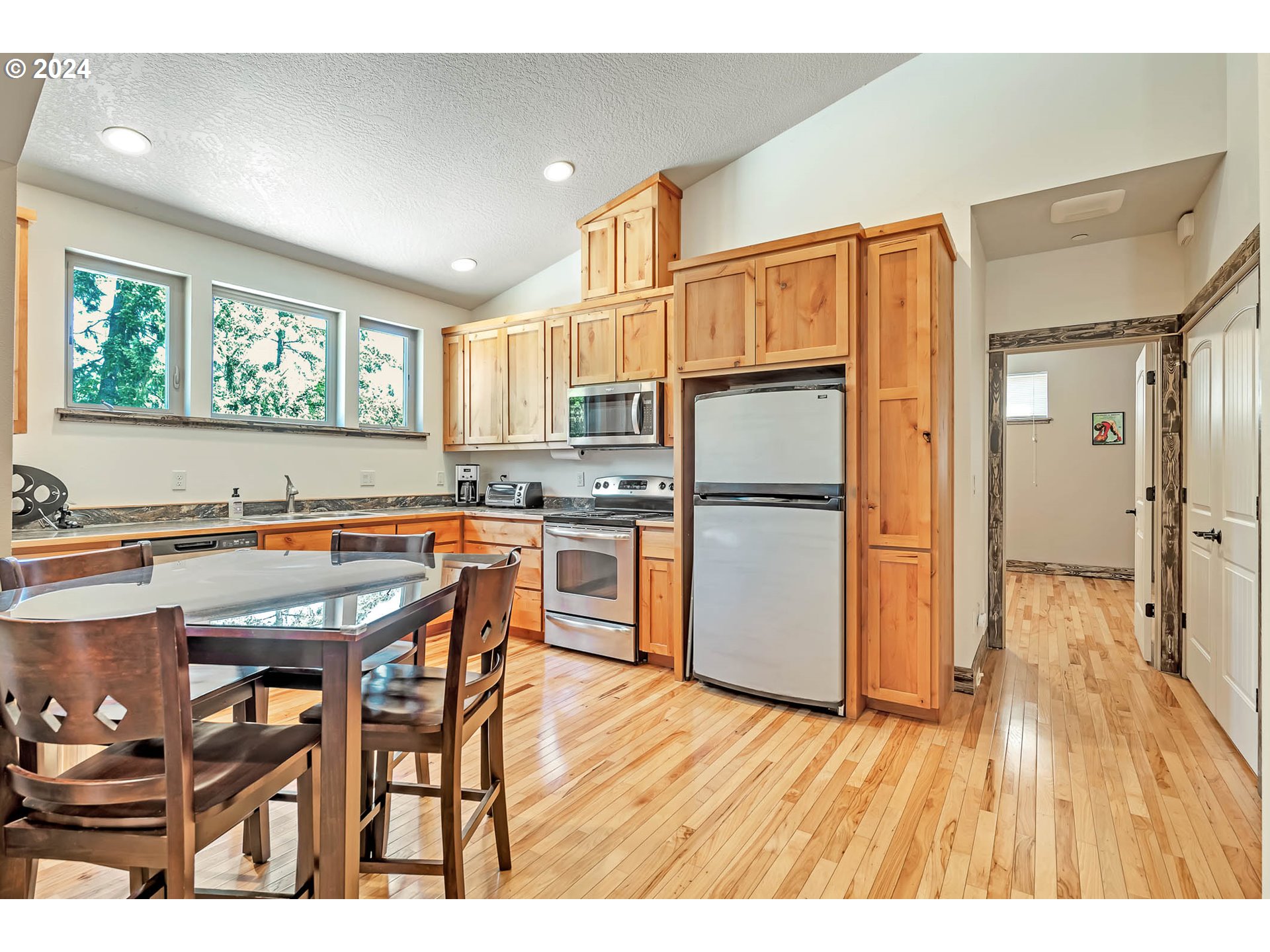 2735 Emerald Street Eugene, OR 97403 - Photo 41 of 47 a kitchen with granite countertop wooden floors and refrigerator