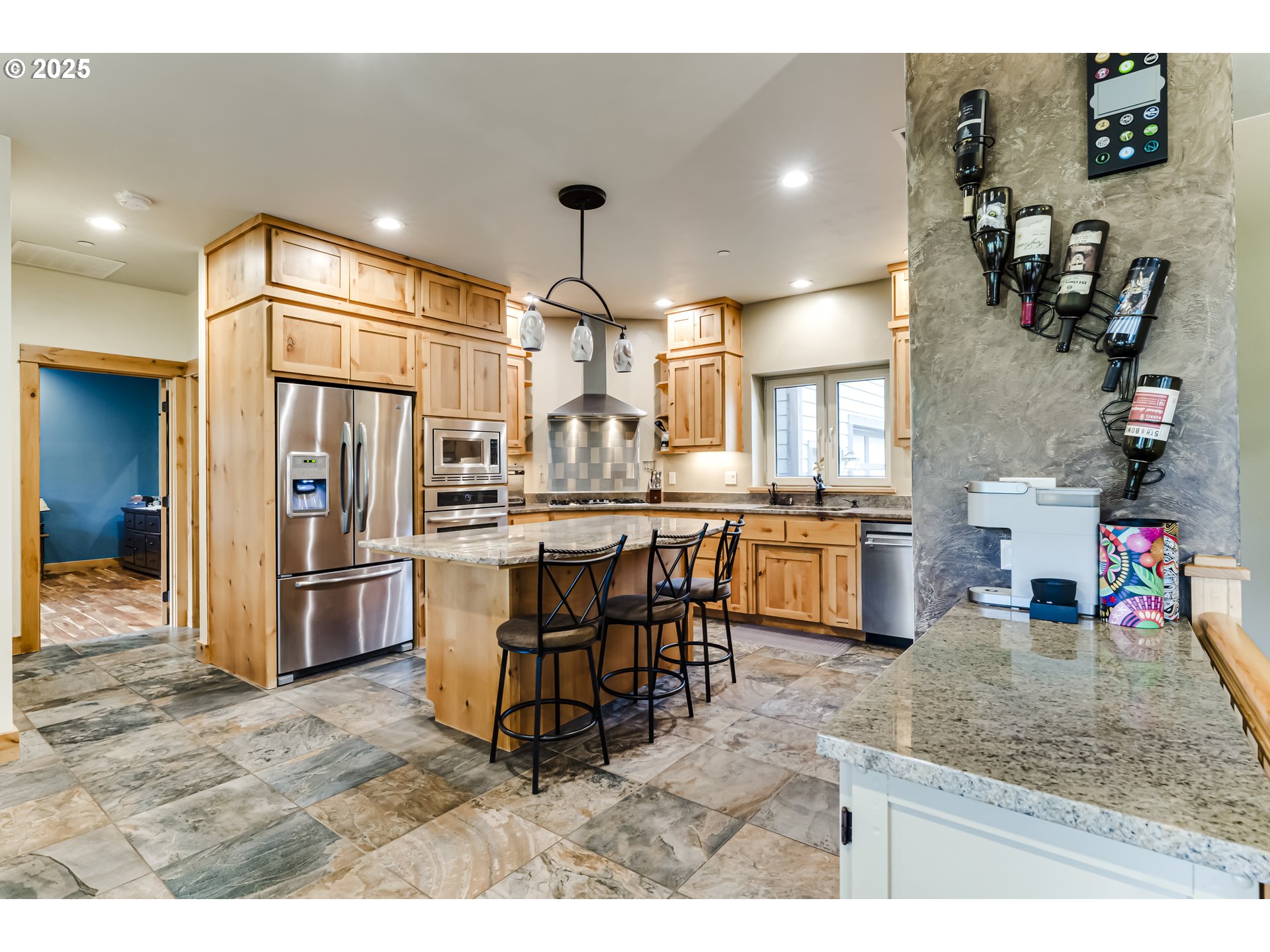 2735 Emerald Street Eugene, OR 97403 - Photo 9 of 47 a kitchen with stainless steel appliances kitchen island granite countertop a refrigerator a sink a stove and chairs with wooden floor