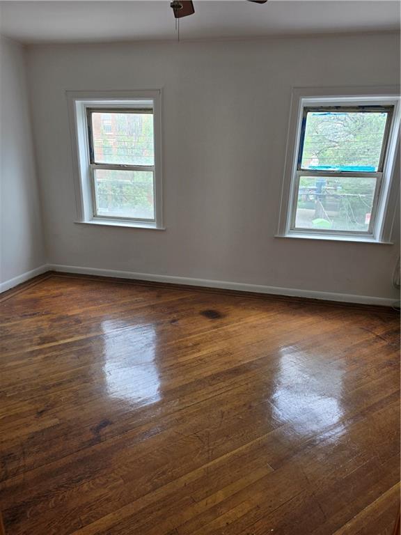 1202 East 38th Street Brooklyn, NY 11210 - Photo 3 of 11 an empty room with wooden floor and windows