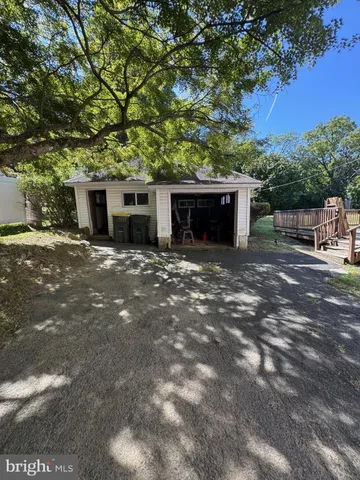 a front view of house with yard and trees in the background