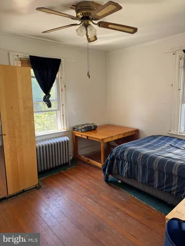 a bedroom with bed and wooden floor