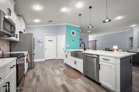 a kitchen with a sink a counter top space stainless steel appliances and a ceiling fan