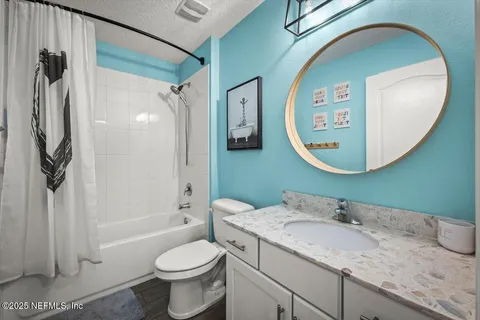 a bathroom with a granite countertop toilet sink and mirror