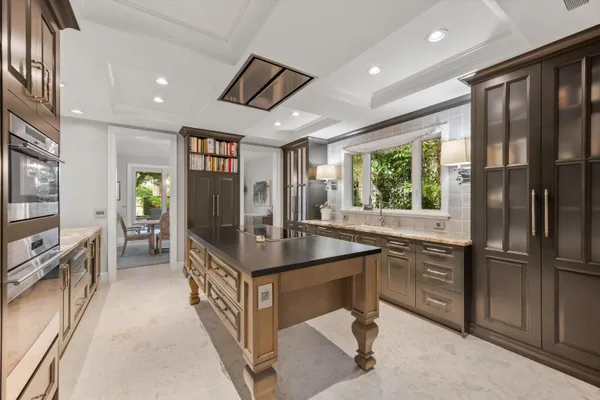 a kitchen with stainless steel appliances granite countertop a refrigerator a stove and a sink