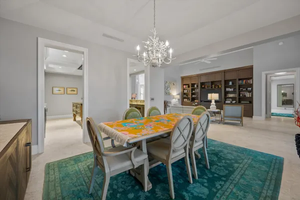 a dining room with furniture a chandelier and window