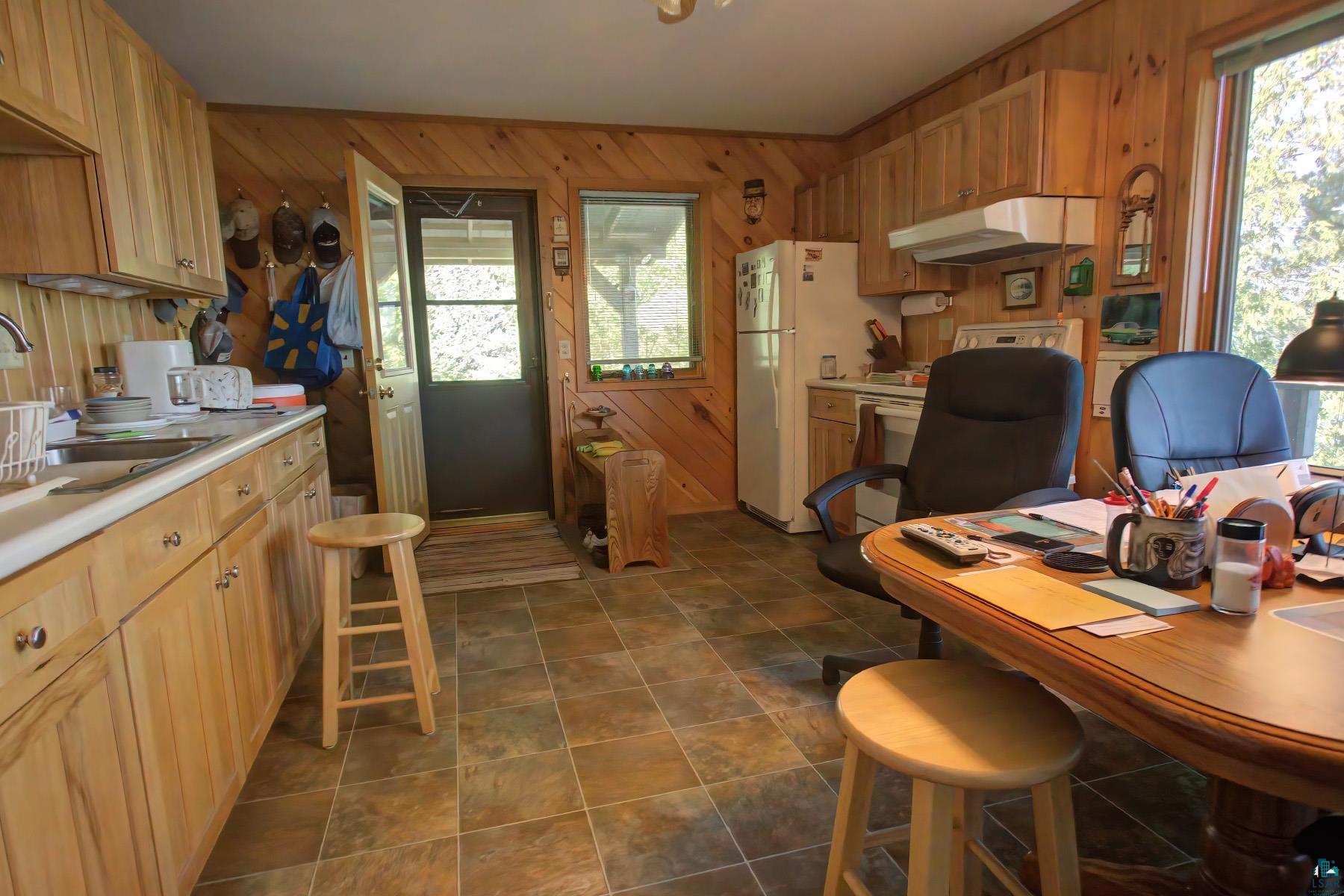 2811 Schaeffer Road Ely, MN 55731 - Photo 23 of 40 Wood-paneled walls and cabinetry, white countertops, tile flooring, and a glass-paned door