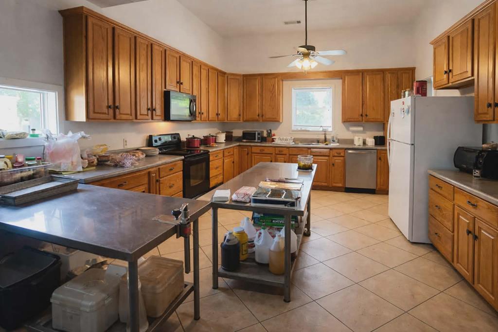1504 Broad Street Lumpkin, GA 31815 - Photo 4 of 7 a kitchen with stainless steel appliances granite countertop a refrigerator a sink dishwasher a stove and white countertops with wooden floor