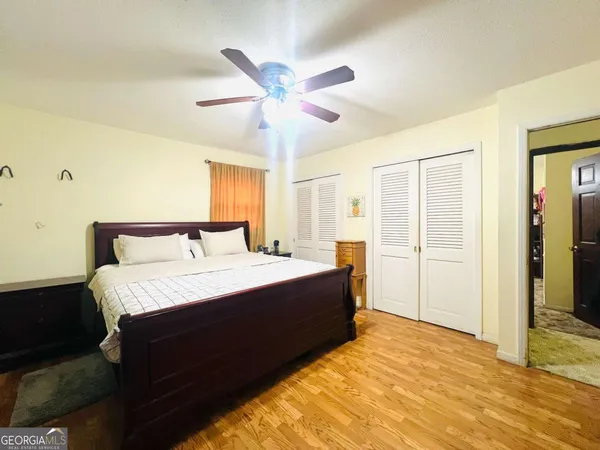 a spacious bedroom with a bed and a mirror