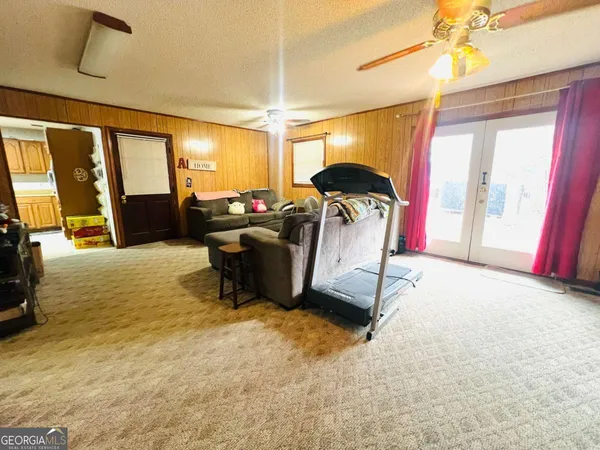 a living room with furniture a flat screen tv and a large window
