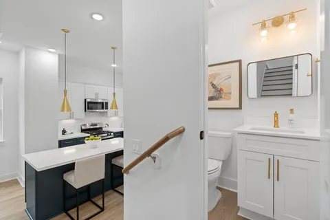 a kitchen with white cabinets and chairs