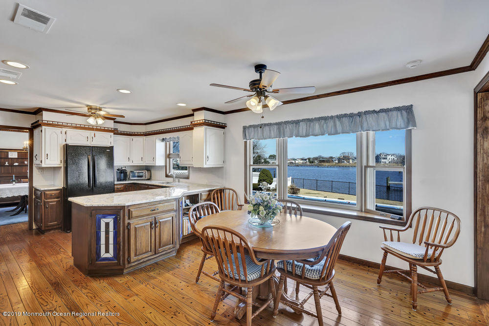 566 Harbor Road Brick, NJ 08724 - Photo 25 of 100 a kitchen with stainless steel appliances granite countertop a stove top oven a sink dishwasher a dining table and chairs with wooden floor