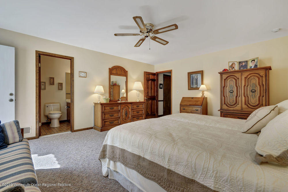 566 Harbor Road Brick, NJ 08724 - Photo 48 of 100 a spacious bedroom with a bed a dresser and a chandelier