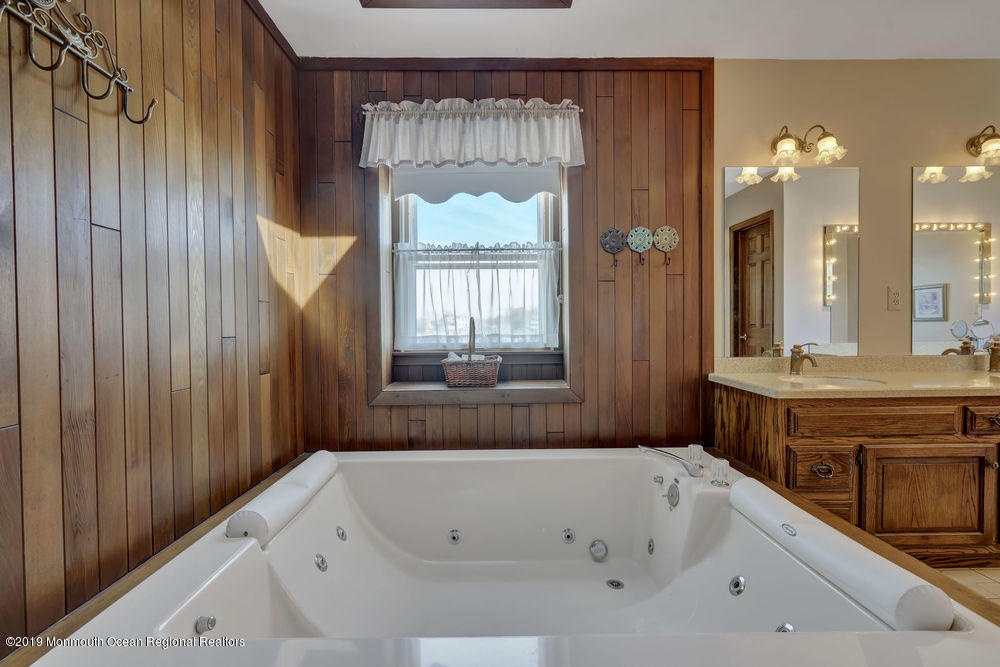 566 Harbor Road Brick, NJ 08724 - Photo 71 of 100 a bathroom with a tub a sink and a large mirror