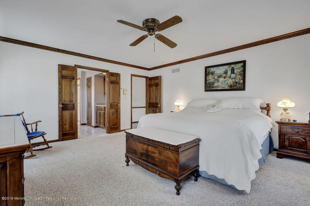 566 Harbor Road Brick, NJ 08724 - Photo 77 of 100 a spacious bedroom with a bed and a chandelier