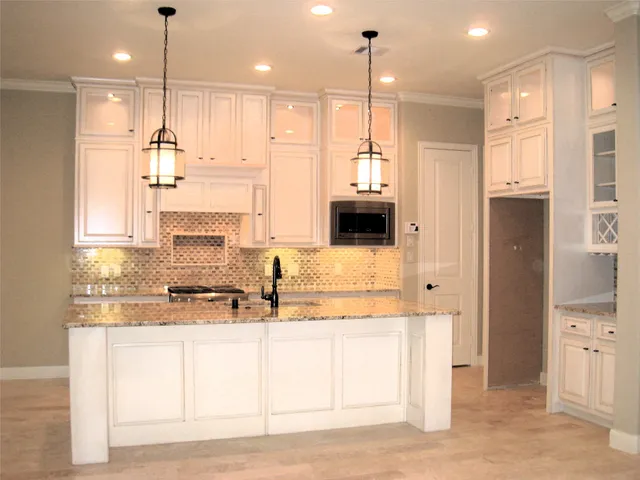 a kitchen with kitchen island granite countertop a stove a sink and a refrigerator