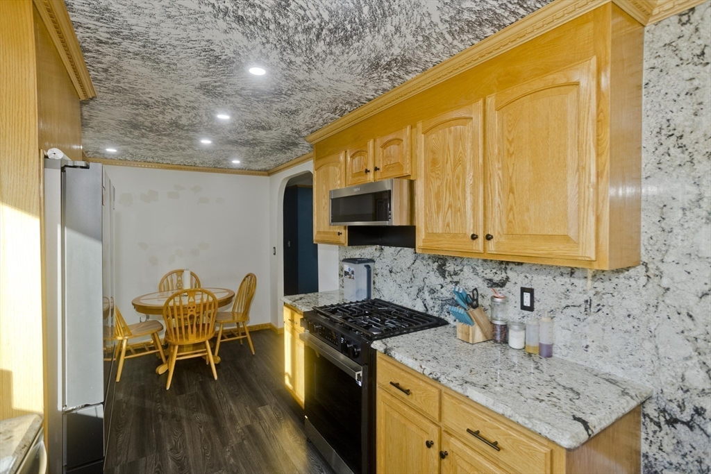 10 View Street Holyoke, MA 01040 - Photo 27 of 38 a kitchen with stainless steel appliances granite countertop a stove a sink dishwasher and a microwave with wooden floor