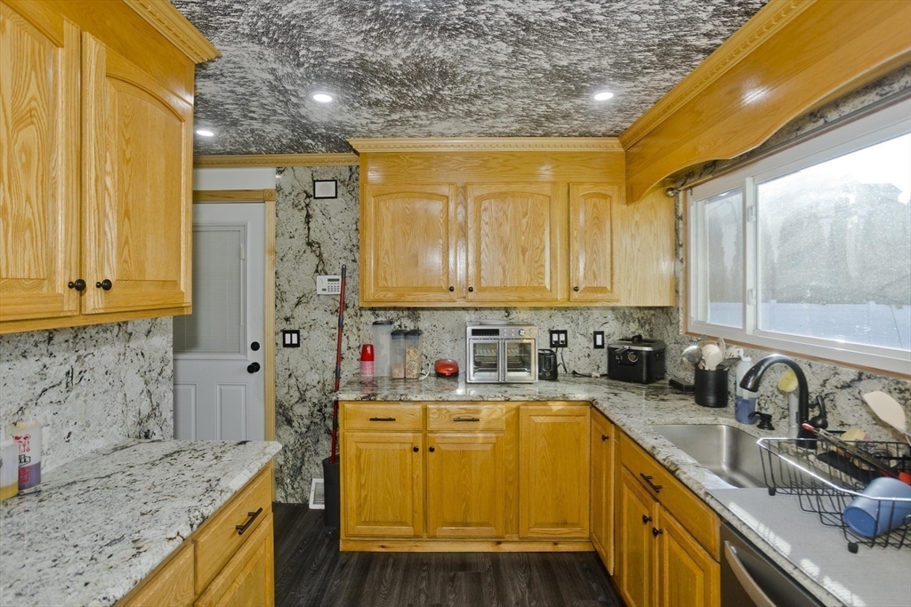 10 View Street Holyoke, MA 01040 - Photo 29 of 38 a kitchen with stainless steel appliances granite countertop a sink a stove and a wooden cabinets