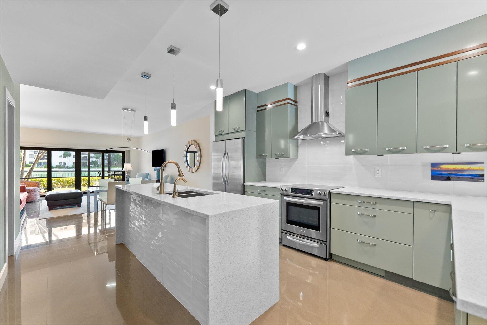a kitchen with kitchen island a large counter top space a sink stainless steel appliances and cabinets