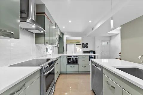 a kitchen with stainless steel appliances a sink stove and cabinets