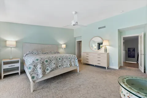 a bedroom with a bed a ceiling fan and a dresser