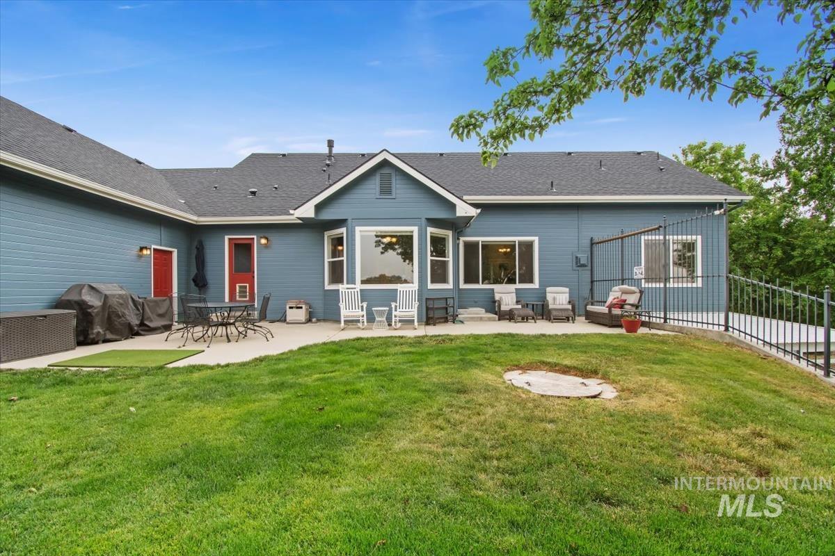 10462 West Lanktree Gulch Road Star, ID 83669 - Photo 40 of 48 Expansive rear exterior featuring a concrete patio, blue siding, a dark shingle roof, and multiple windows