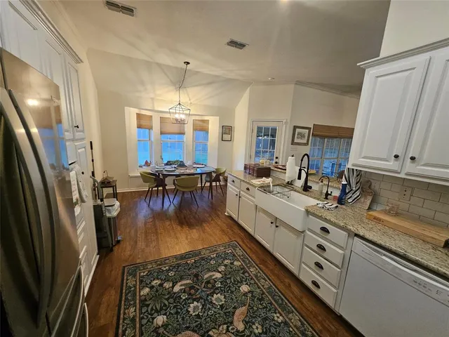 a large white kitchen with lots of counter space and stainless steel appliances