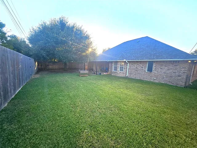 a view of a backyard with a small cabin and wooden fence