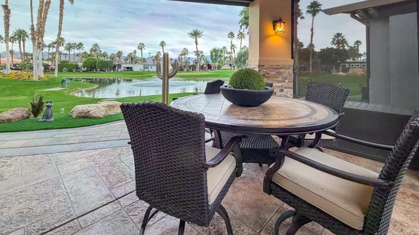 a view of a patio with a table chairs and a yard
