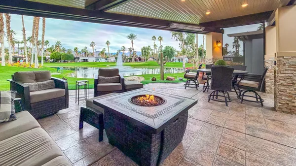 a view of a patio with table and chairs under an umbrella
