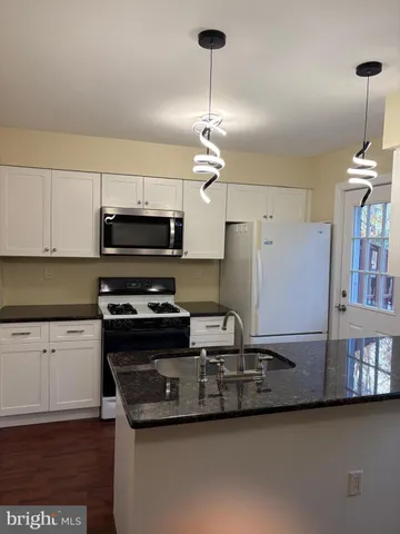 a kitchen with kitchen island a sink appliances and cabinets