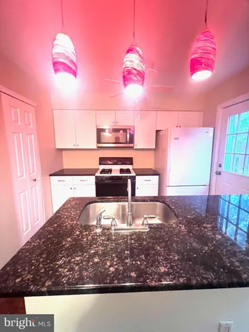 a view of kitchen with microwave and refrigerator
