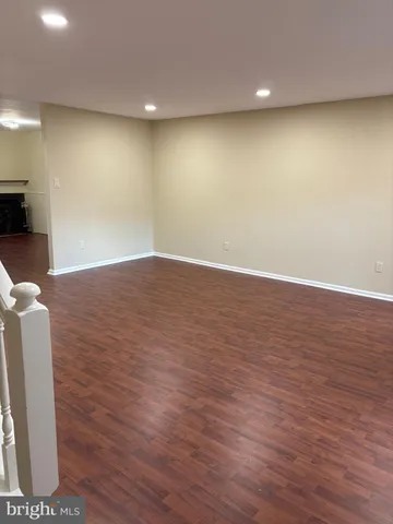 an empty room with wooden floor and a bathroom
