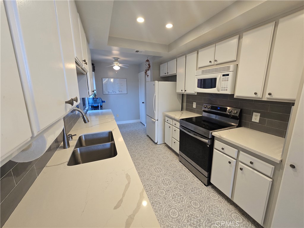 8828 Pershing Drive, Unit 121 Playa del Rey, CA 90293 - Photo 1 of 54 a kitchen that has a sink and a stove top oven