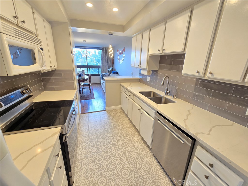 8828 Pershing Drive, Unit 121 Playa del Rey, CA 90293 - Photo 6 of 54 a kitchen with a sink a stove and cabinets