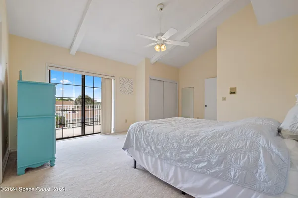 a spacious bedroom with a large bed and a chandelier