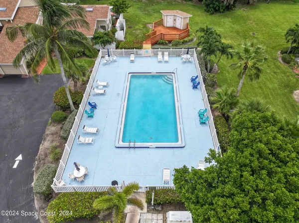 an aerial view of residential houses with outdoor space and trees