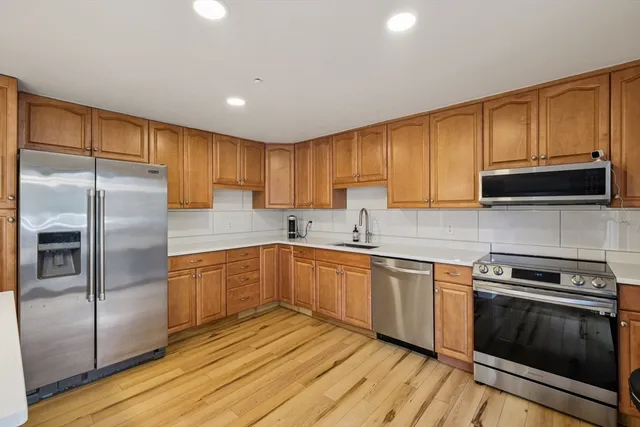 a kitchen with wooden cabinets and stainless steel appliances