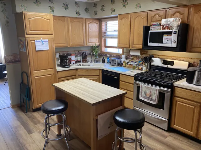 a kitchen with stainless steel appliances a stove a refrigerator and a stove top oven