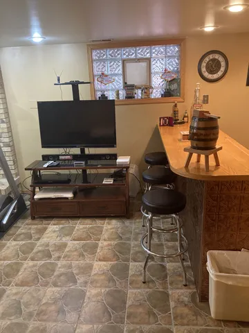 a living room with a table chairs and a refrigerator