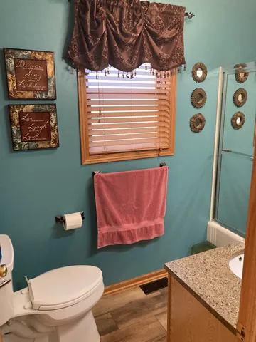 a bathroom with a toilet a sink and a window